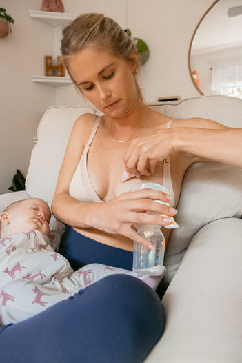 Woman using Lactation Massager for mastitis while nursing.